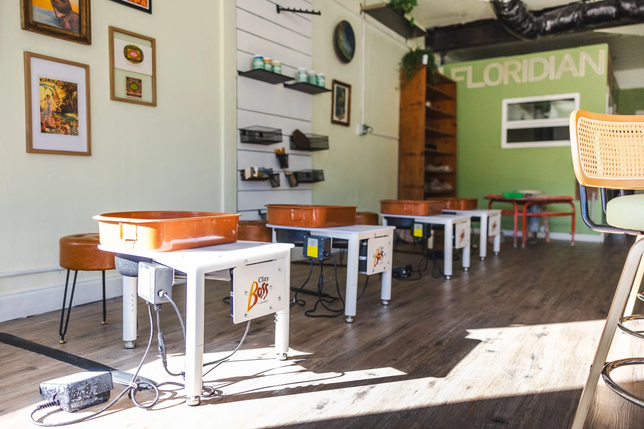 Inside the Floridian Ceramics studio: pottery wheels, framed Florida prints and the green Floridian wall